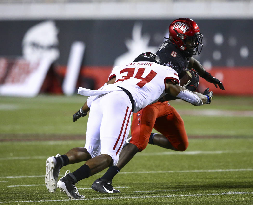 UNLV Rebels running back Charles Williams (8) tries to get past Arkansas State Red Wolves defen ...
