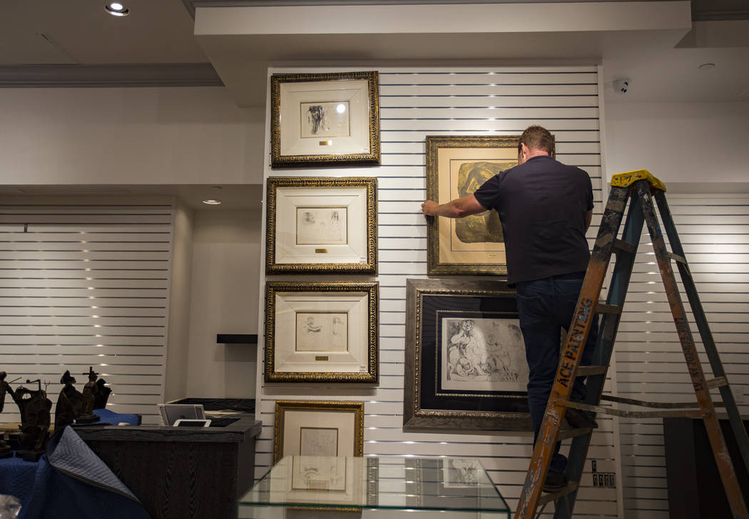 Chad Sampson, the Rick Harrison Collection art dDirector, places a drawing on the wall at the n ...