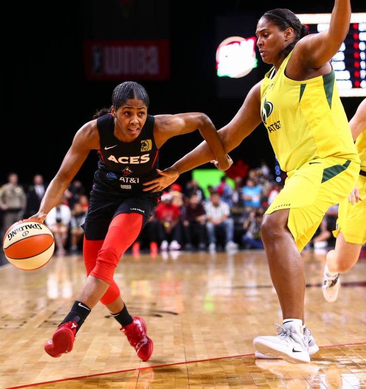 Las Vegas Aces' Sydney Colson, left, drives to the basket against Seattle Storm's Courtney Pari ...