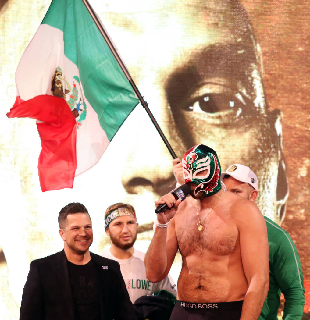 Boxer Tyson Fury wears a lucha libre mask as he speaks to the crowd at a weigh-in at the KA The ...
