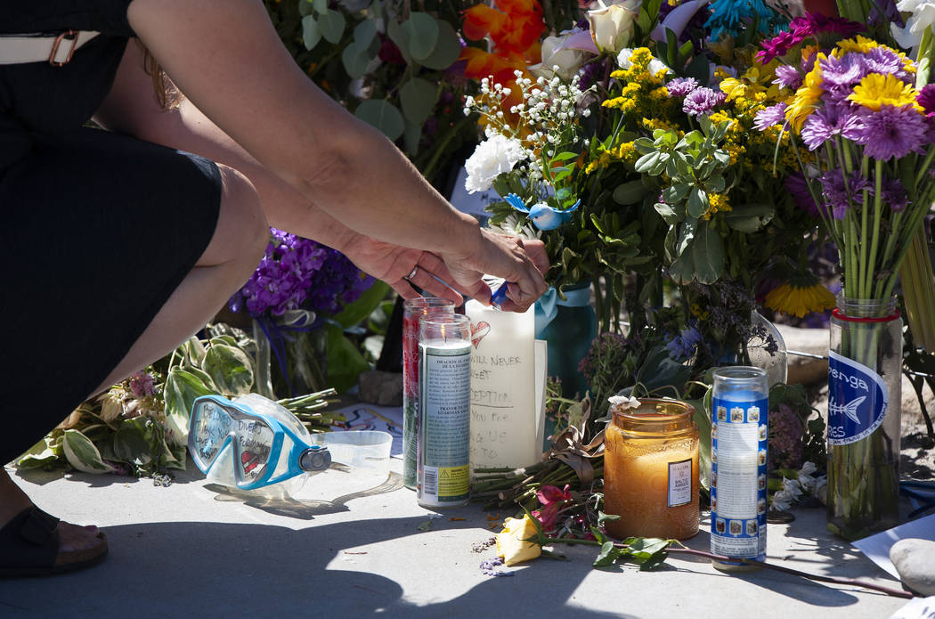 A woman relights a candle placed at a memorial for the victims of the Conception dive boat on t ...