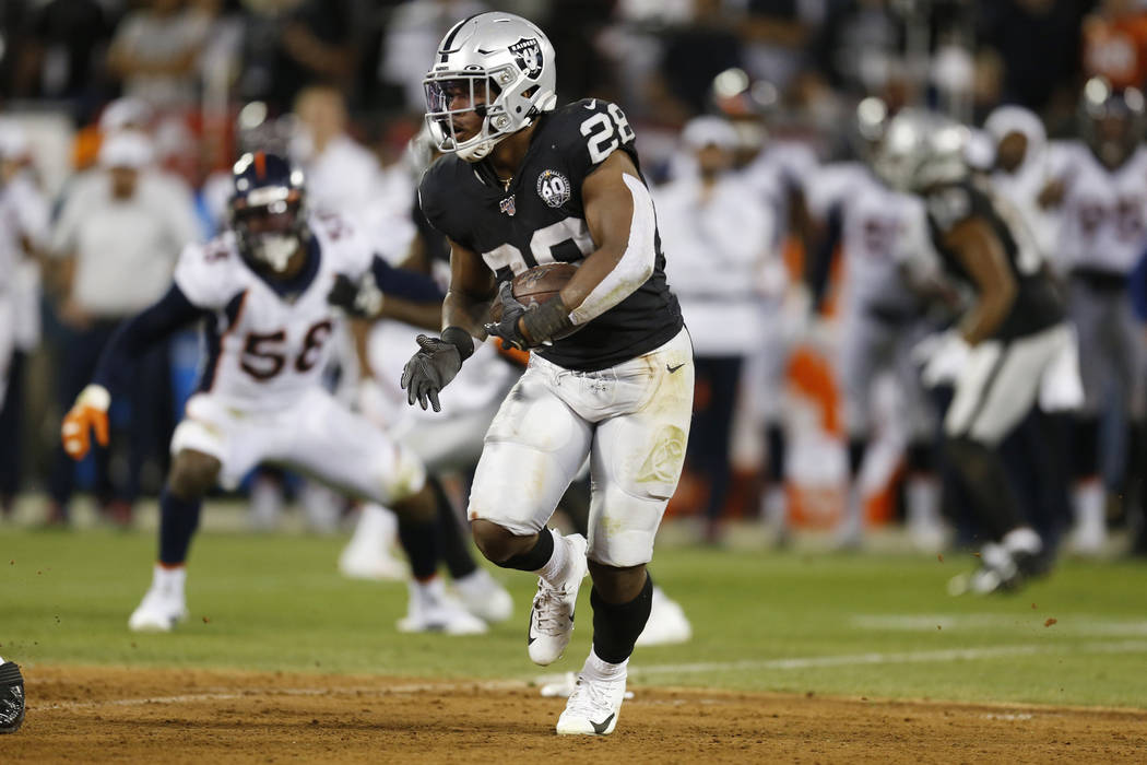 Oakland Raiders running back Josh Jacobs runs with the ball during the first half of an NFL foo ...