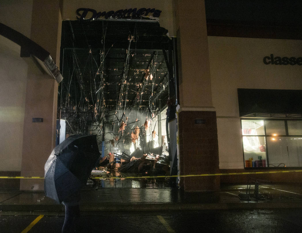 In this Tuesday, Sept. 10, 2019 photo, a passerby walks past a damaged store after severe weath ...