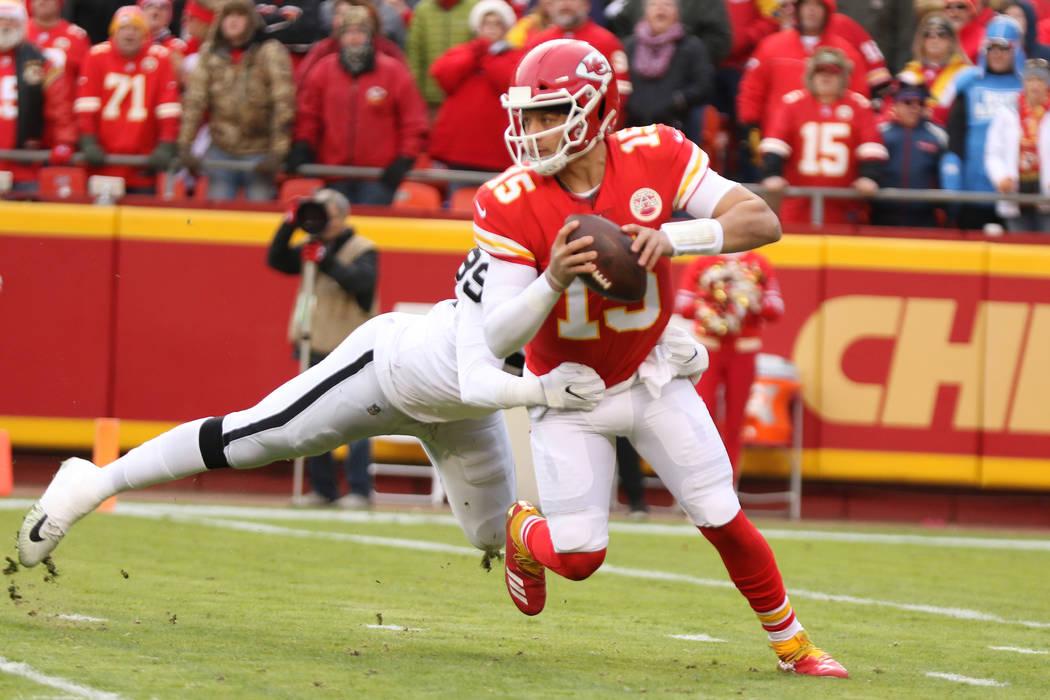 Kansas City Chiefs quarterback Patrick Mahomes (15) sheds a tackle by Oakland Raiders defensive ...