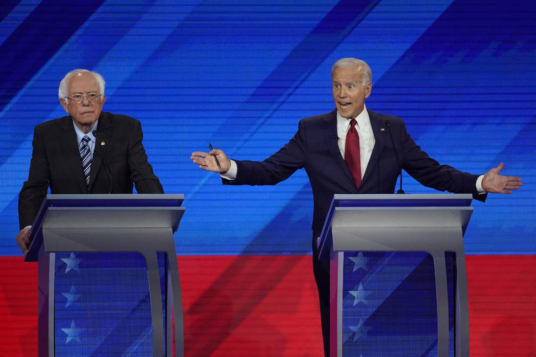 Sen. Bernie Sanders, I-Vt., left, listens as former Vice President Joe Biden, right, responds t ...