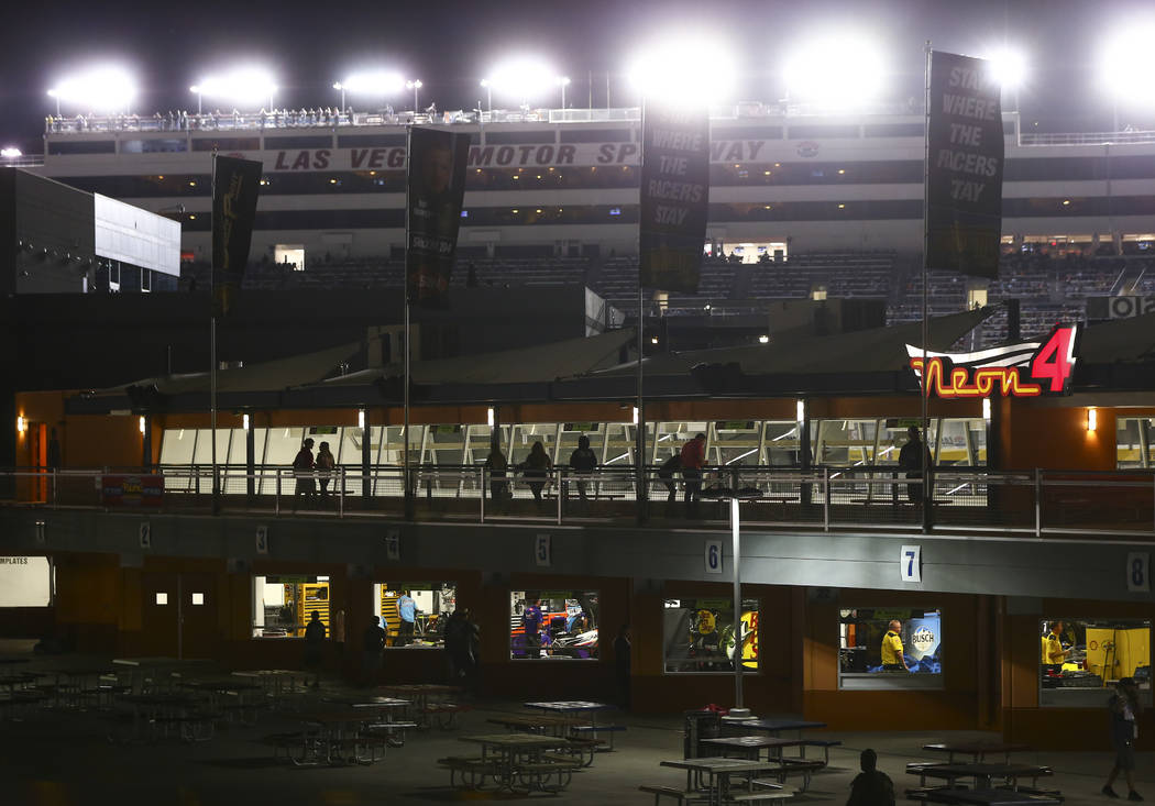 Attendees walk through the garage area as drivers compete during the NASCAR World of Westgate 2 ...