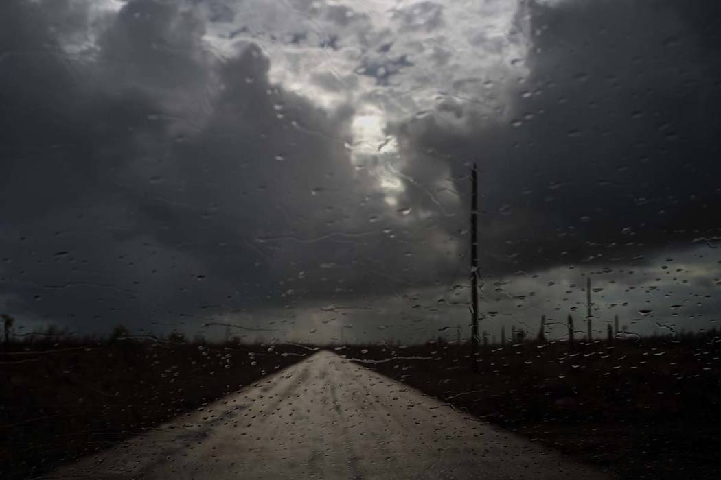 Rain prior to the arrival of the tropical depression falls on the windshield of a car in the af ...