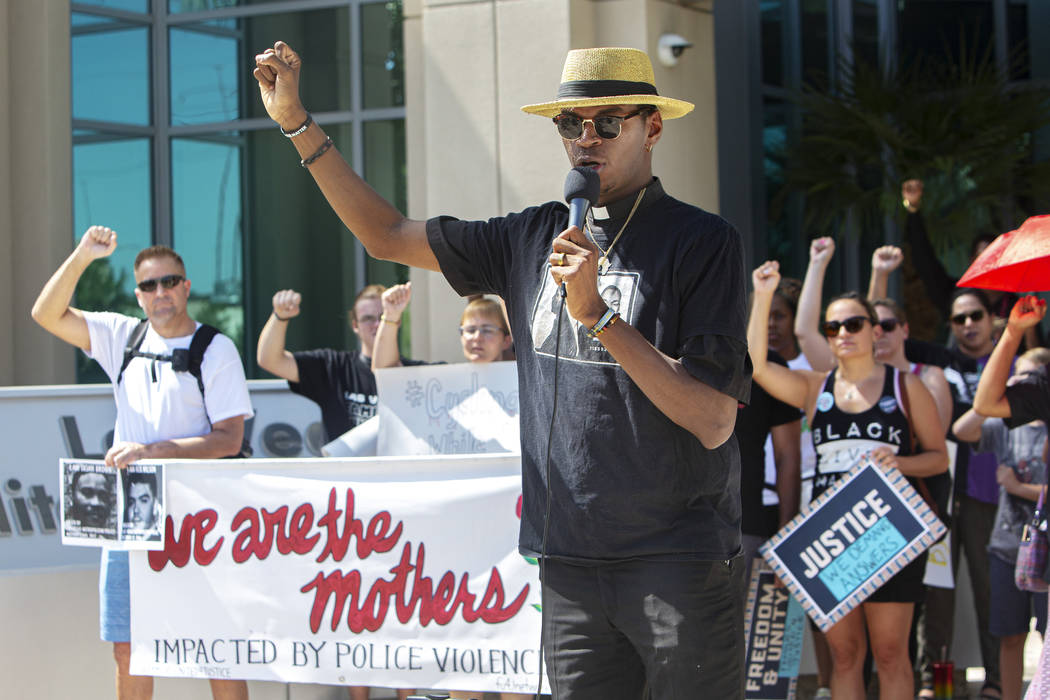 Reverend Stretch Sanders puts a fist up during a rally to protest the death of Byron Williams, ...