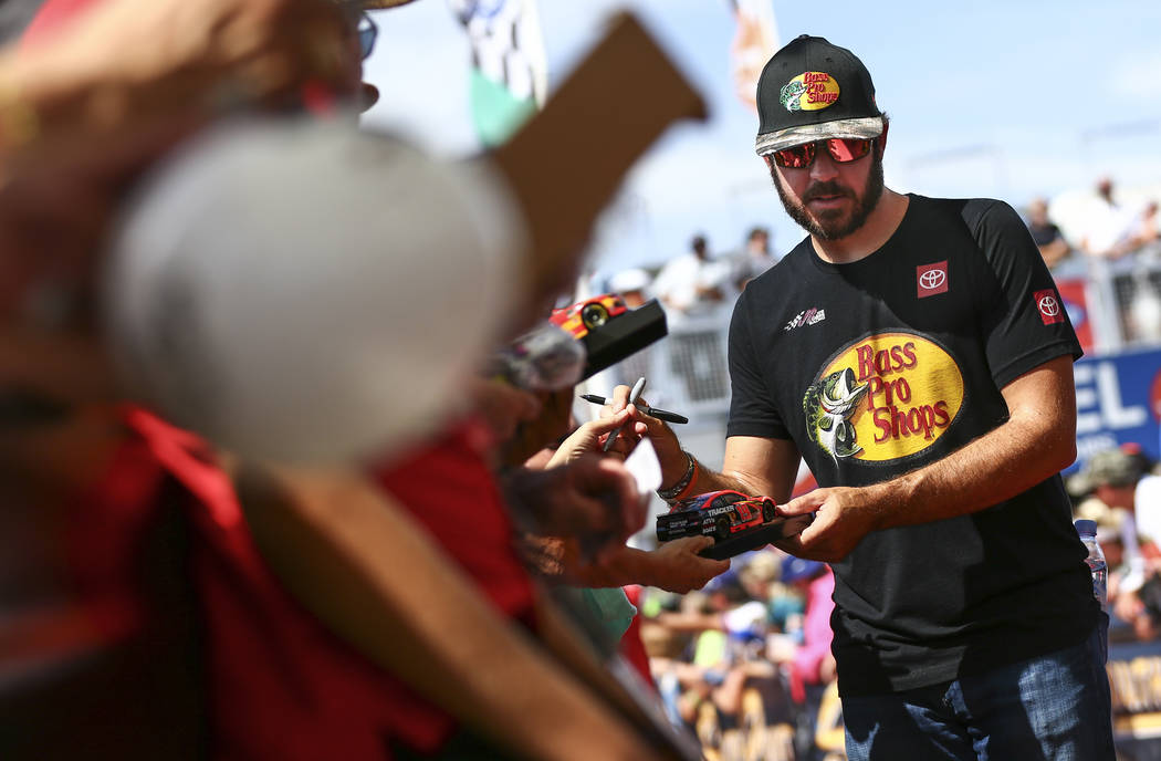 Martin Truex Jr. gives autographs to fans before a NASCAR Cup Series auto race at Las Vegas Mot ...