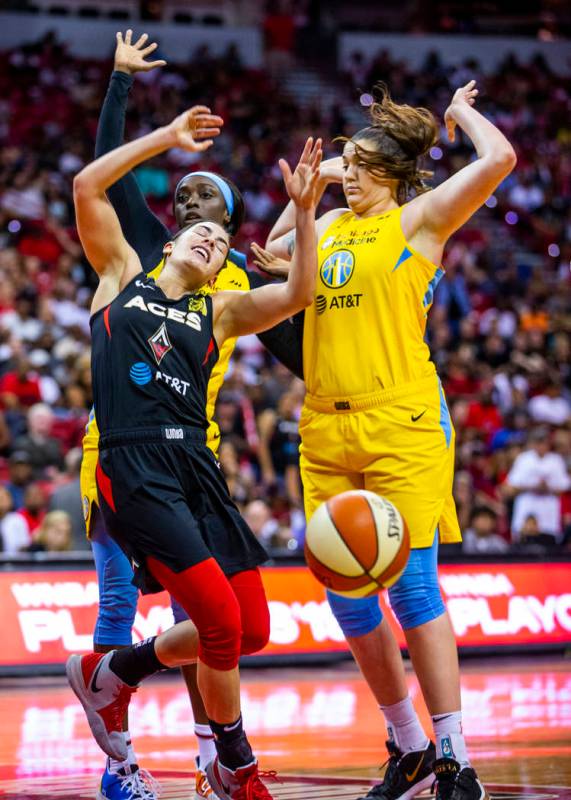 Las Vegas Aces guard Kelsey Plum (10, left) reacts to a hard shot from Chicago Sky guard Kahlea ...