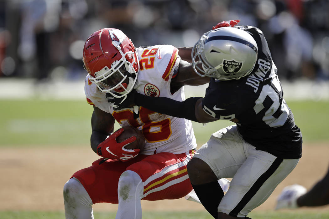 Kansas City Chiefs running back Damien Williams tries to break away from Oakland Raiders free s ...