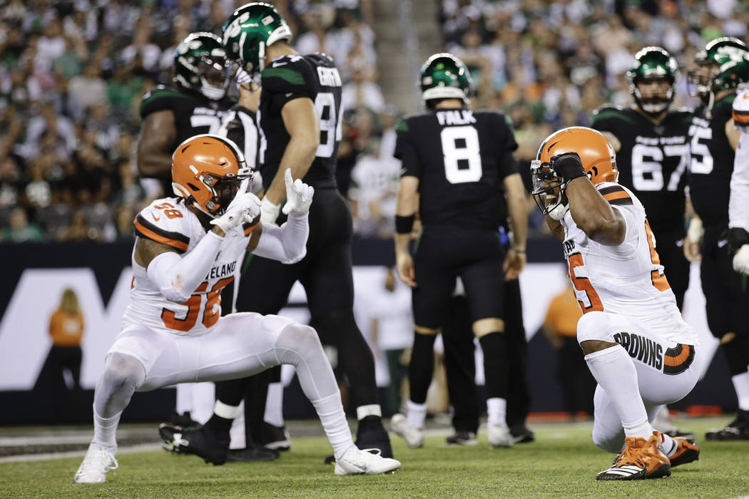 Cleveland Browns' Christian Kirksey (58) celebrates with Myles Garrett (95) after Garrett sacke ...