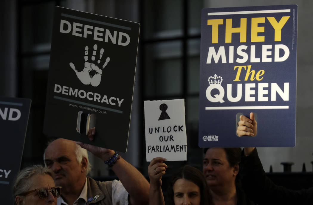 Protesters hold banners outside the Supreme Court in London, Tuesday Sept. 17, 2019. The Suprem ...