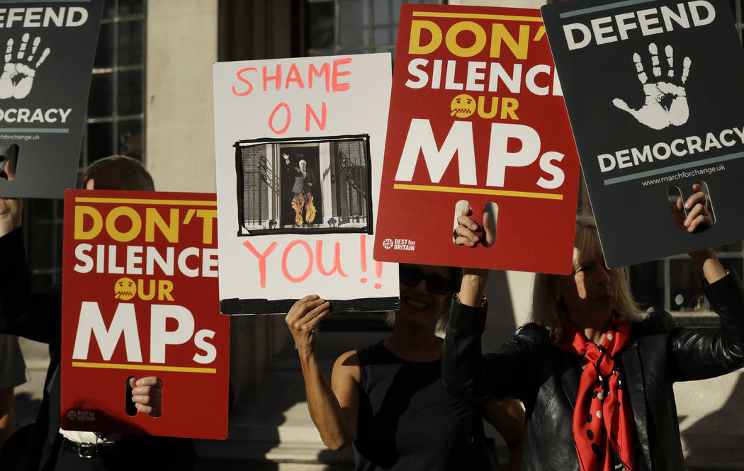 Protesters hold banners outside the Supreme Court in London, Tuesday Sept. 17, 2019. The Suprem ...