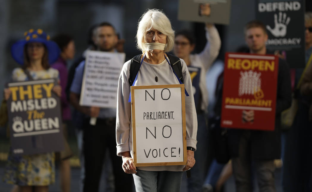 Protesters hold banners outside the Supreme Court in London, Tuesday Sept. 17, 2019. The Suprem ...