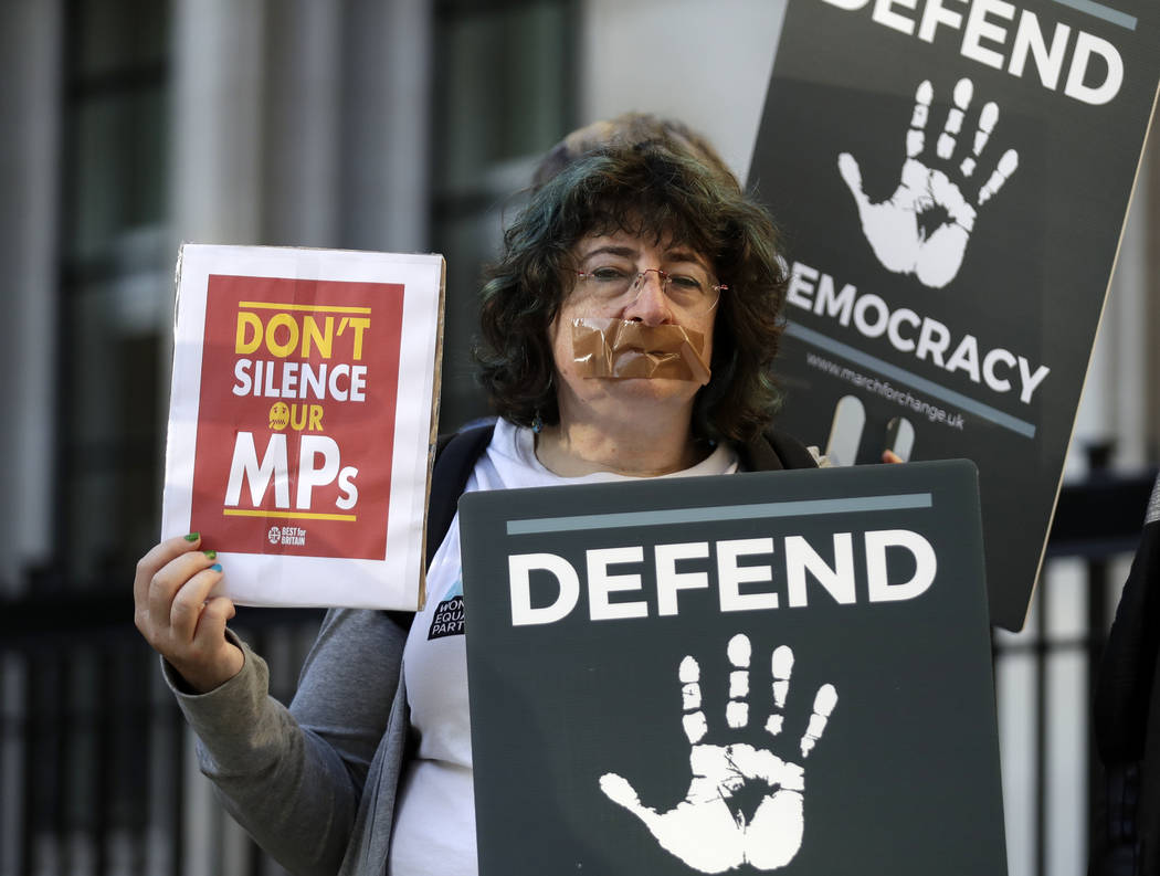 Protesters hold banners outside the Supreme Court in London, Tuesday Sept. 17, 2019. The Suprem ...