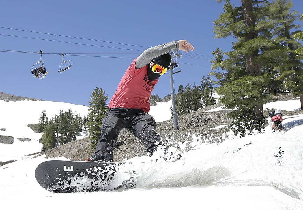 FILE - In this July 1, 2017 file photo, a snowboarder cuts throughout the snow at the Squaw Val ...