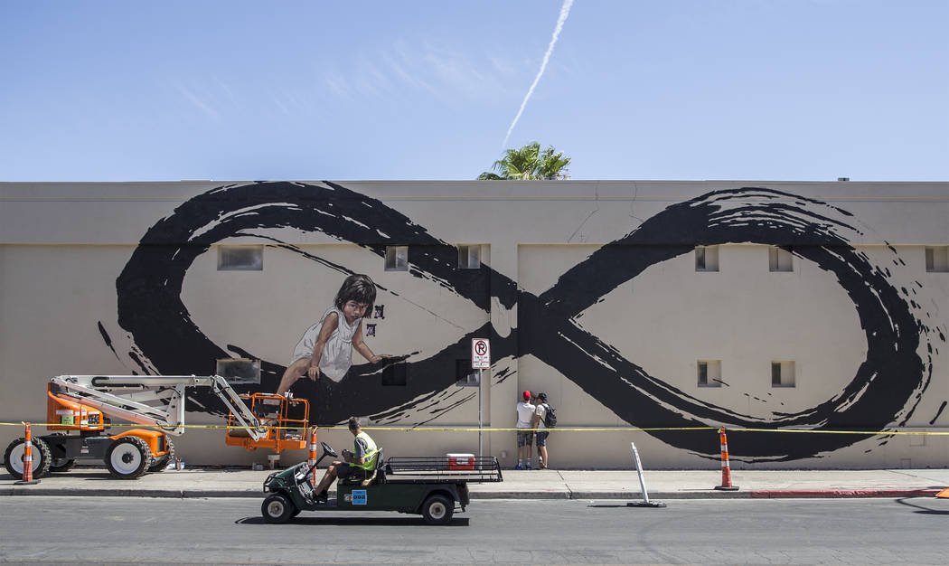 Lithuania artist Ernest Zacharevic, center, and Nicky Holiday discuss Zacharevic's mural in pre ...