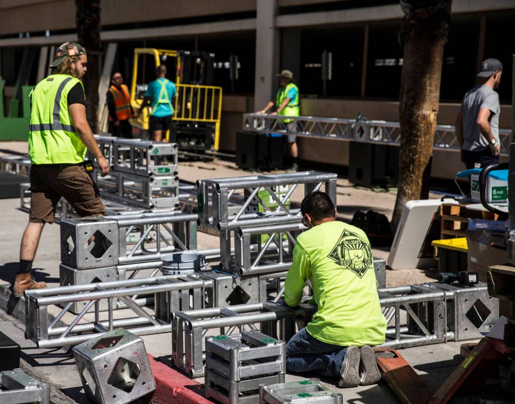 Workers build piping for stages at the intersection of North 7th Street and East Ogden Avenue i ...