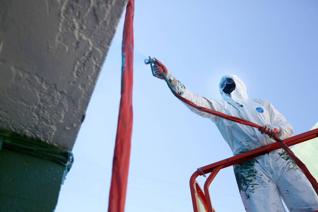 Producer Mike Bronke from Chicago paints a coat of vibrant paint for the Bacardi Art Motel in p ...