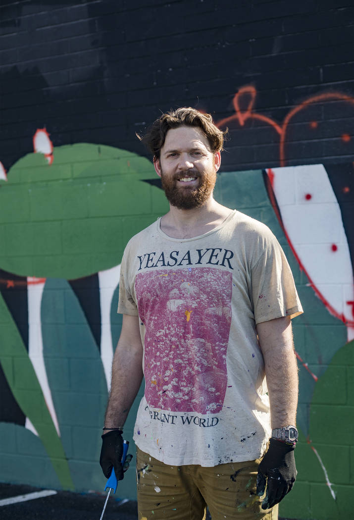 Artist Eric Vozzola stands in front of his mural-in-progress "An Allegory of Natural Beaut ...