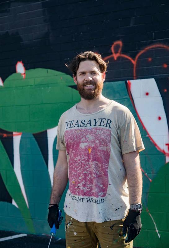 Artist Eric Vozzola stands in front of his mural-in-progress "An Allegory of Natural Beaut ...