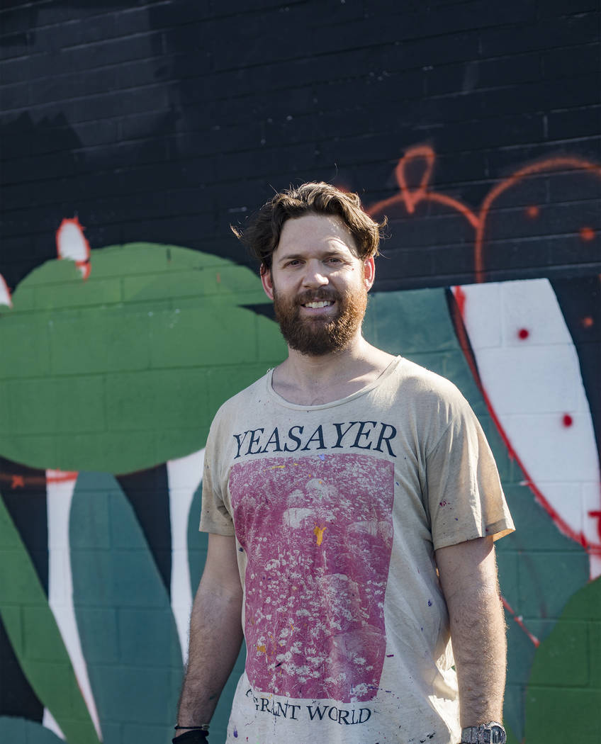 Artist Eric Vozzola stands in front of his mural-in-progress "An Allegory of Natural Beaut ...