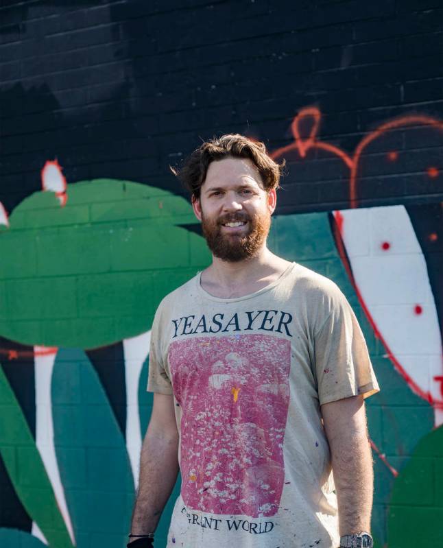 Artist Eric Vozzola stands in front of his mural-in-progress "An Allegory of Natural Beaut ...