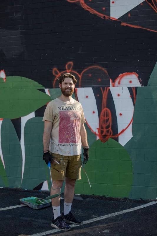 Artist Eric Vozzola stands in front of his mural-in-progress "An Allegory of Natural Beaut ...