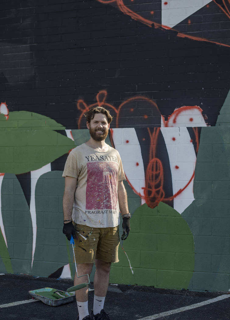 Artist Eric Vozzola stands in front of his mural-in-progress "An Allegory of Natural Beaut ...