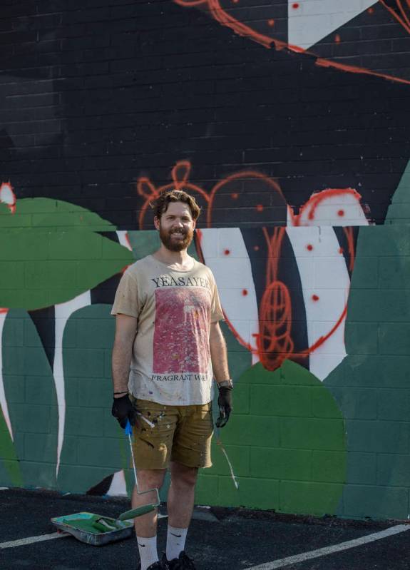 Artist Eric Vozzola stands in front of his mural-in-progress "An Allegory of Natural Beaut ...