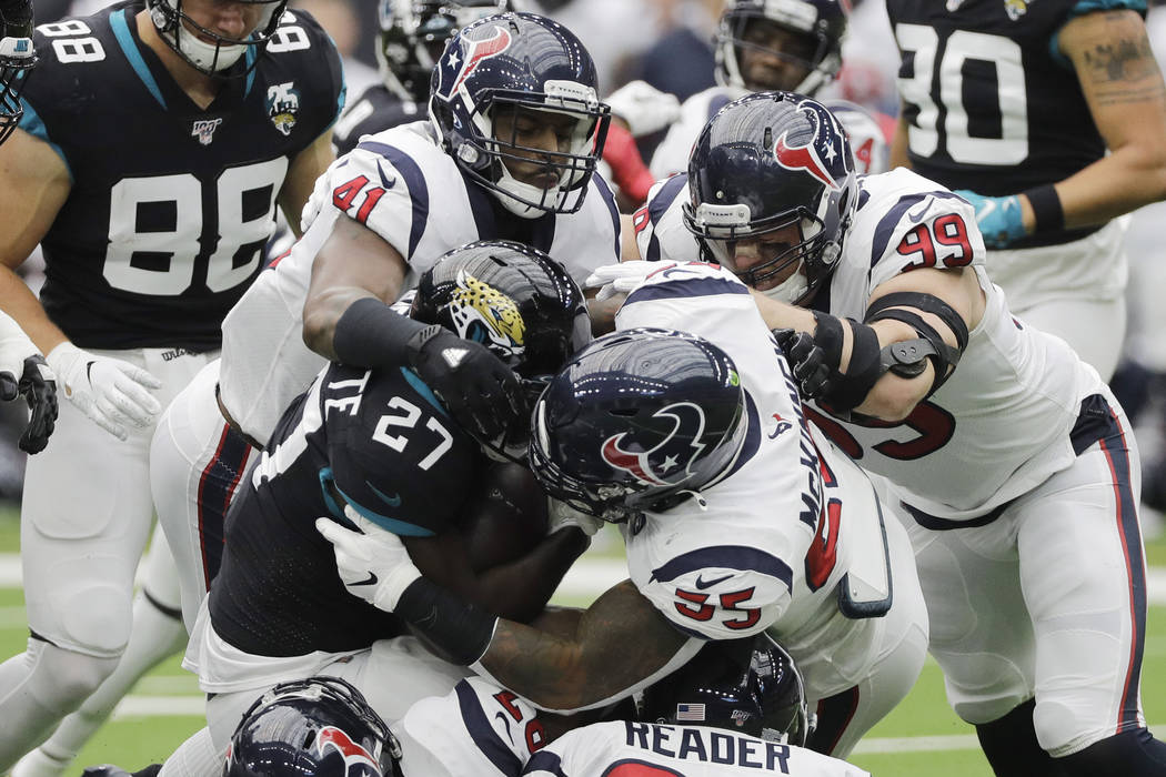 Jacksonville Jaguars running back Leonard Fournette (27) is stopped by Houston Texans inside li ...