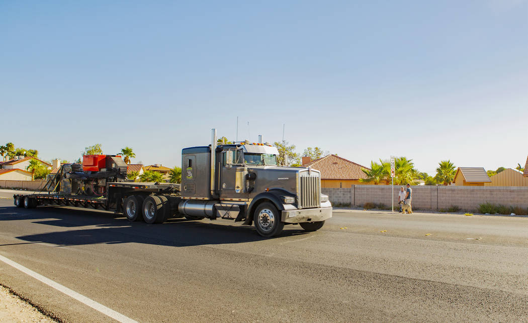 A truck drives through a no-trucks zone as Trevor Schneider and Jim Ludwick, background, watch ...