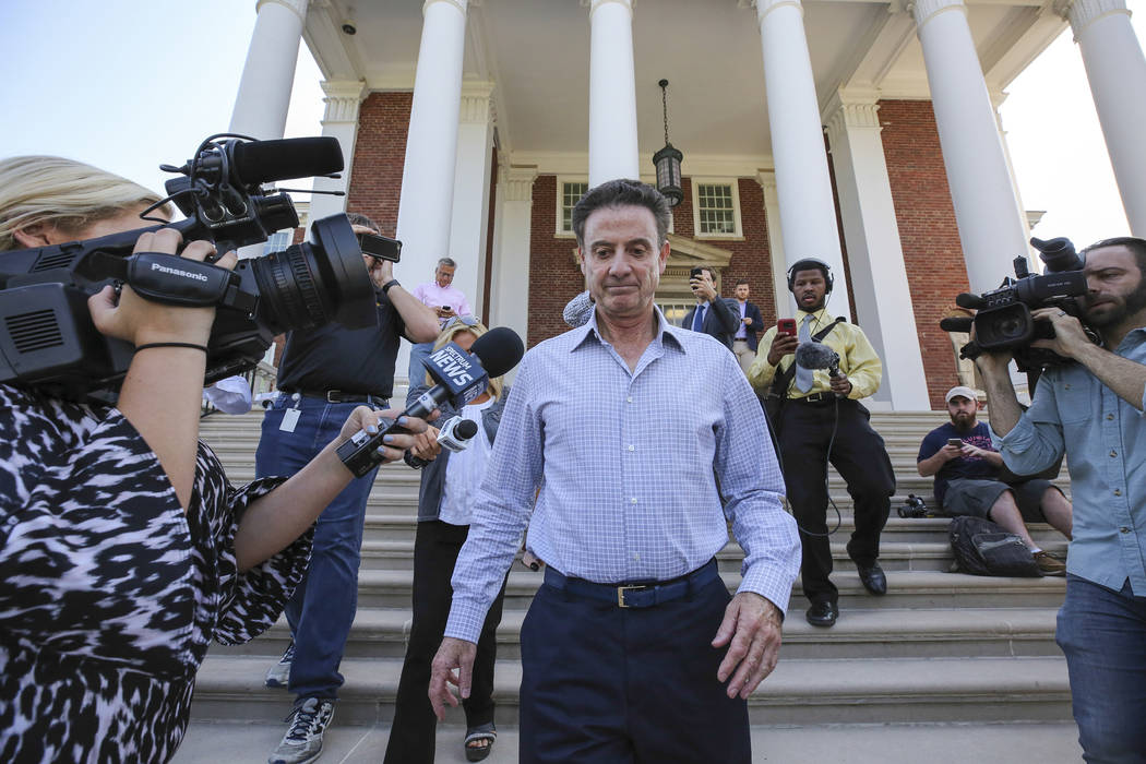 Then-Louisville men's basketball coach Rick Pitino leaves Grawemeyer Hall after having a meetin ...