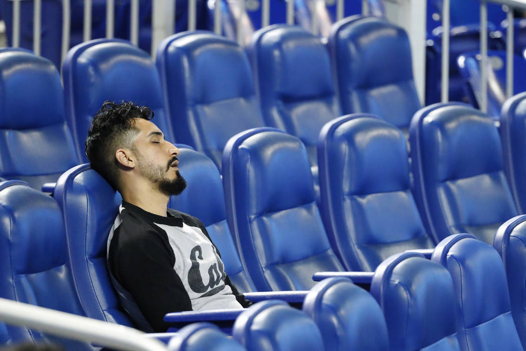 A spectator naps during the playing of the National Anthem before the start of a baseball game ...