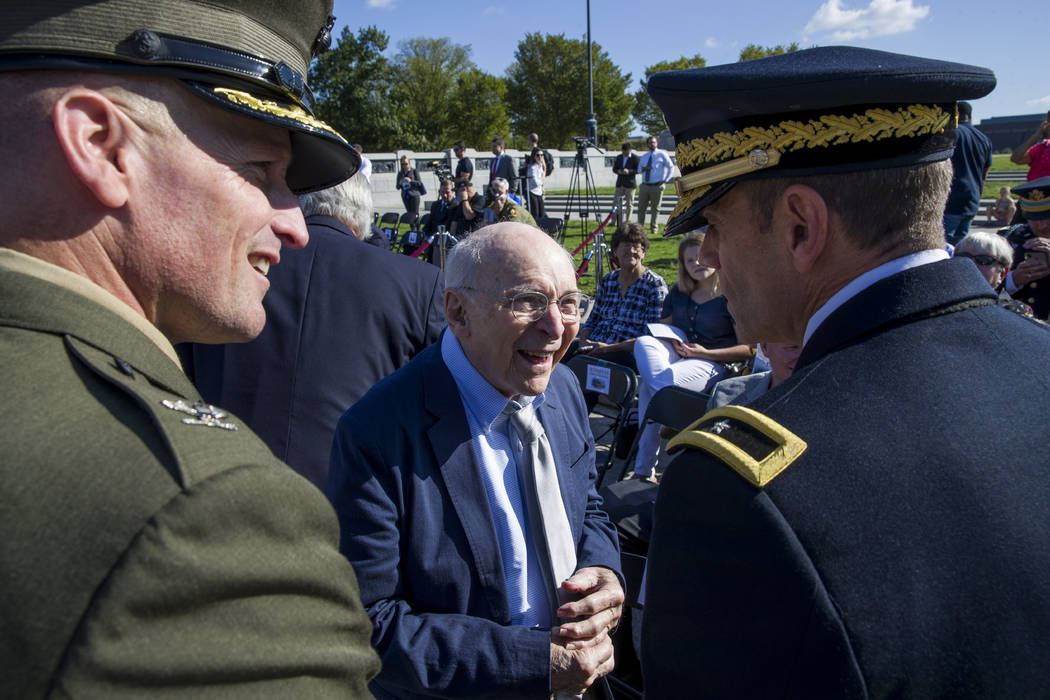 World War II veteran Buck Marsh, center, talks with two active duty military members before a c ...