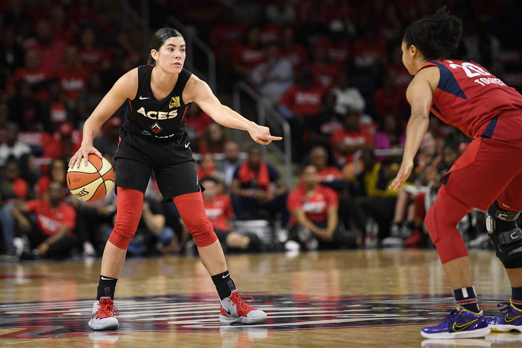 Las Vegas Aces guard Kelsey Plum, left, dribbles the ball against Washington Mystics guard Kris ...