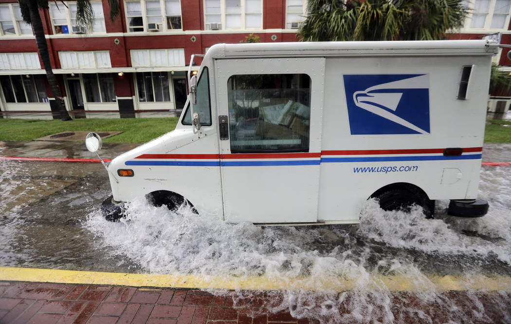 A postal truck drives through floodwaters from Tropical Depression Imelda, Wednesday, Sept. 18, ...