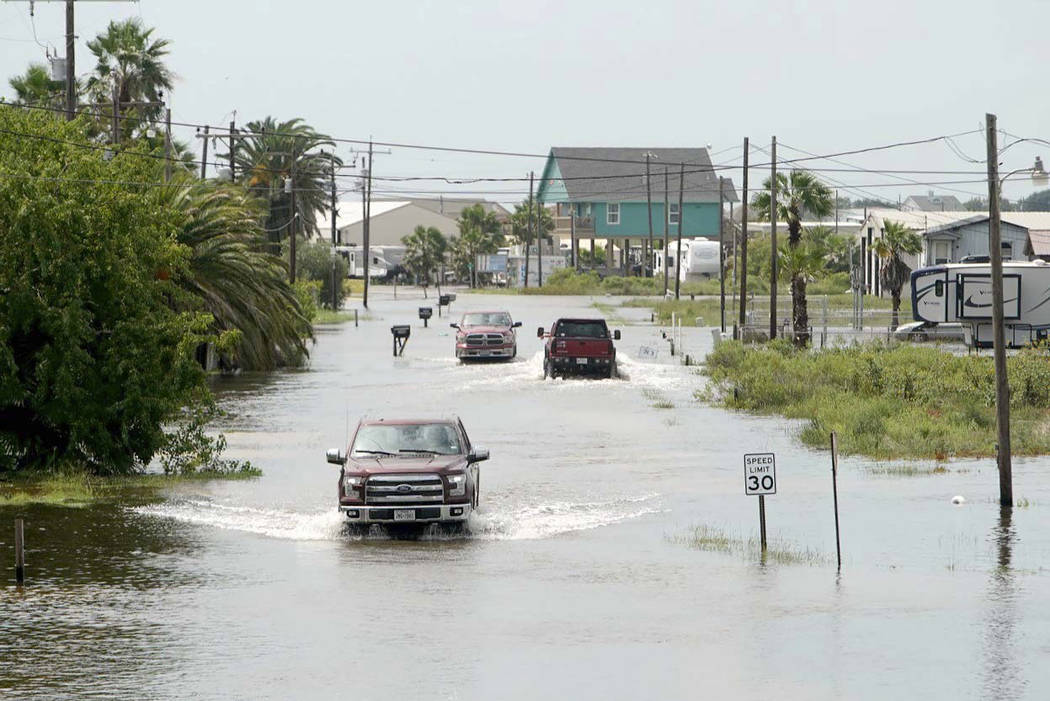 Trucks drive down Carancahua Street to enter neighborhoods in Sargent, Texas, Wednesday, Sept. ...