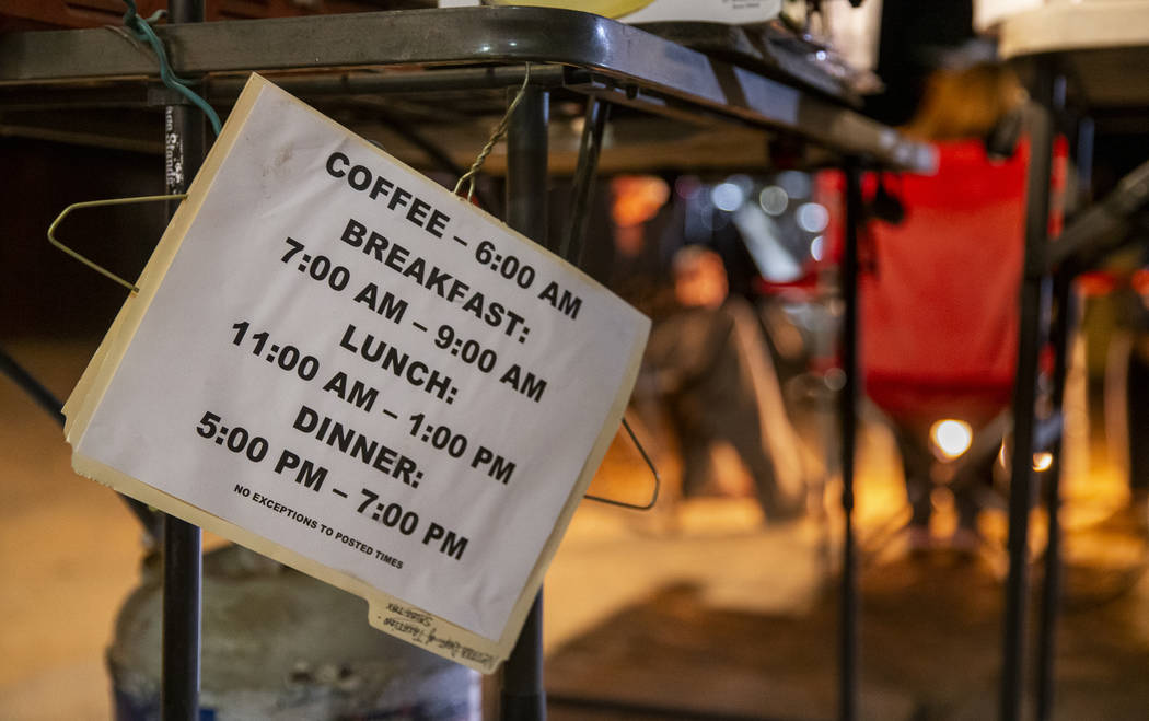 Meal times are posted while friends hang out and warm up by a gas fire pit near the main stage ...