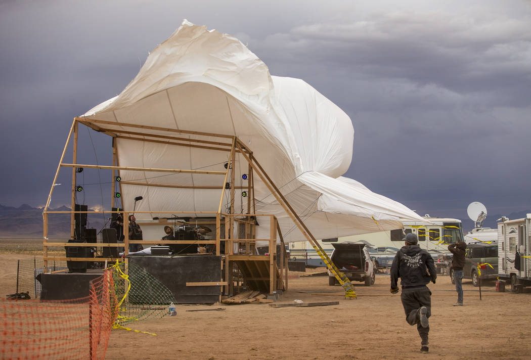 The roof tarp on the main stage begins to blow off from increasing winds as the start of the Al ...