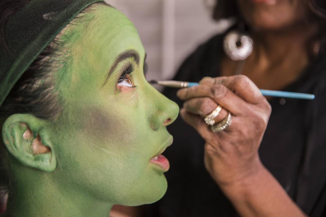 Mariand Torres, left, who plays Elphaba in "Wicked," gets her makeup done by makeup supervisor ...