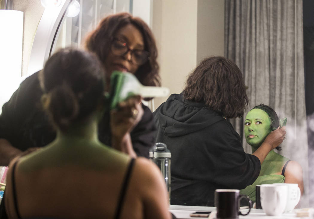 Mariand Torres, right, who plays Elphaba in "Wicked," gets her makeup done by makeup supervisor ...