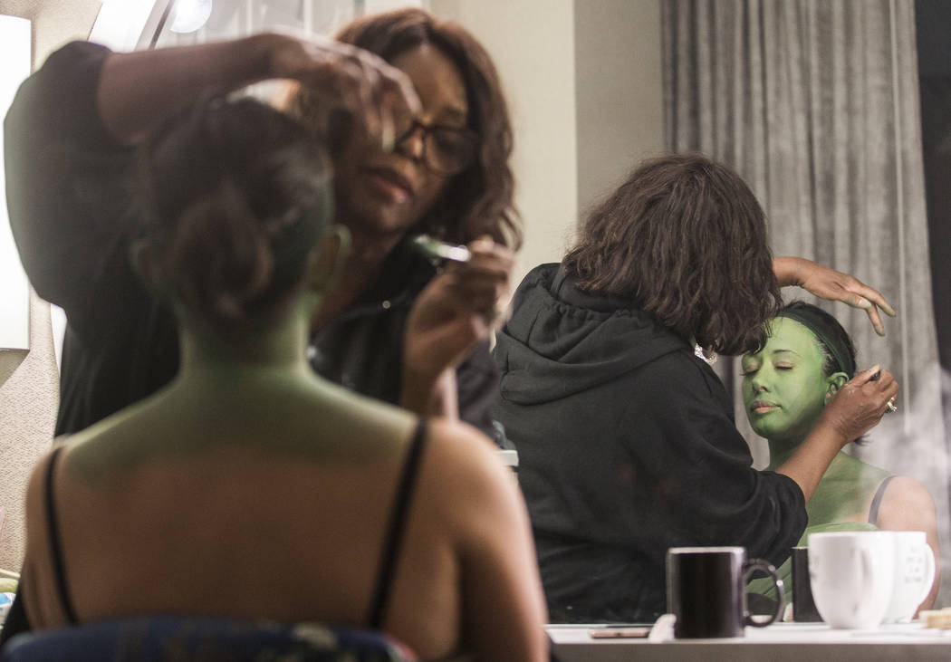 Mariand Torres, right, who plays Elphaba in "Wicked," gets her makeup done by makeup supervisor ...