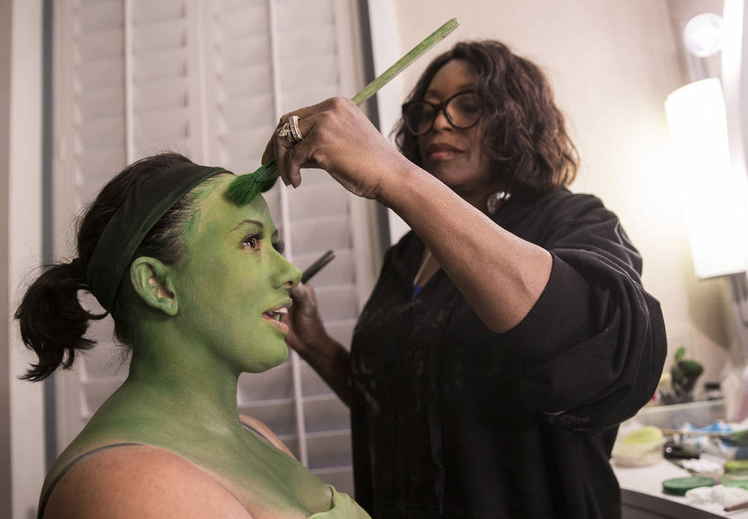 Mariand Torres, left, who plays Elphaba in "Wicked," gets her makeup done by makeup supervisor ...