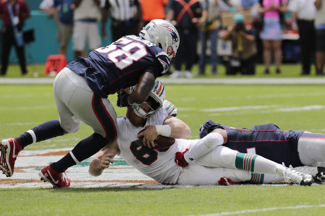 New England Patriots outside linebackers Jamie Collins (58) and Elandon Roberts (52) sack Miami ...