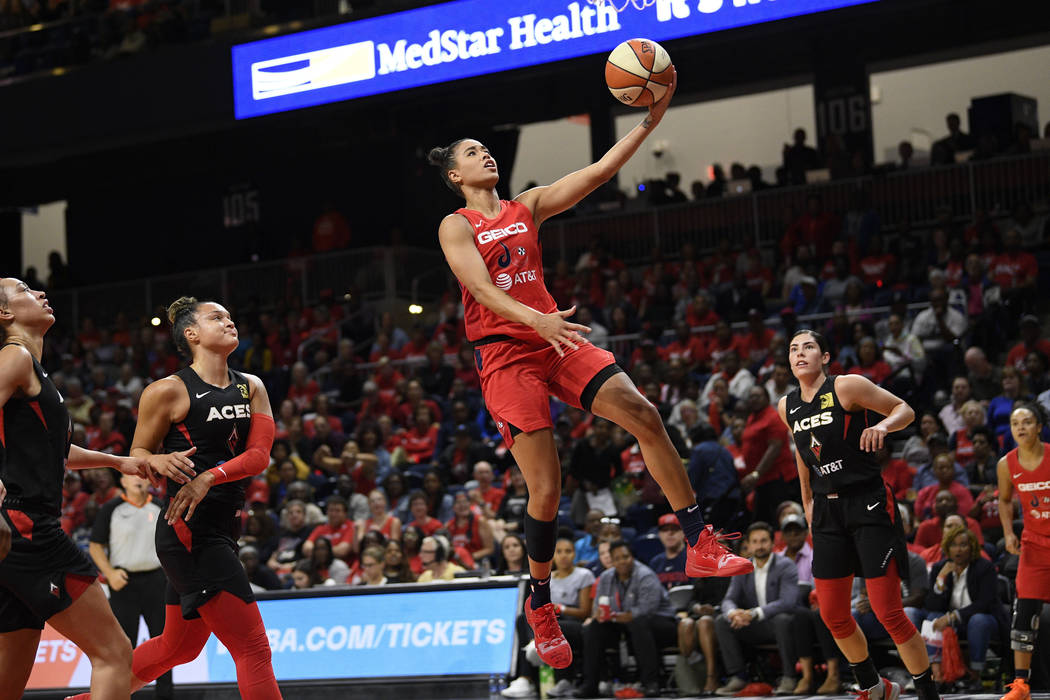 Washington Mystics guard Natasha Cloud, center, goes to the basket between Las Vegas Aces guard ...