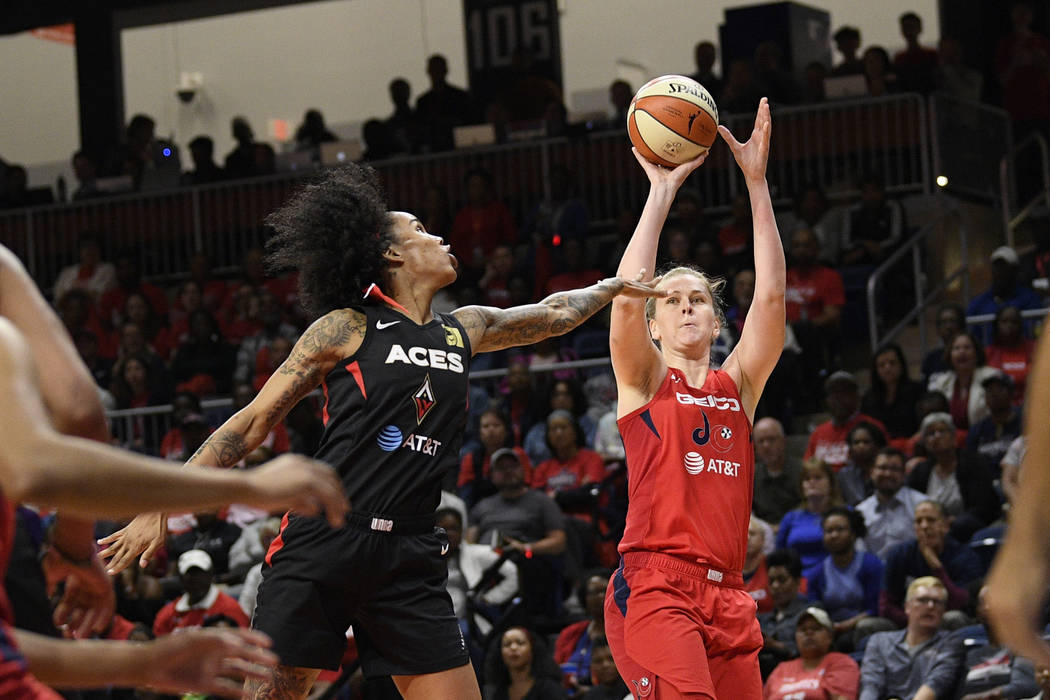 Washington Mystics center Emma Meesseman shoots against Las Vegas Aces forward Tamera Young dur ...