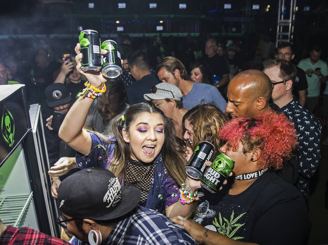 Attendees swarm a free case of special alien edition Bud Light during the Area 51 Celebration o ...