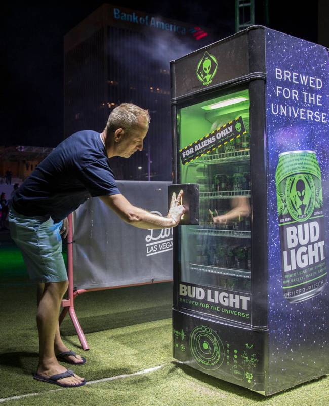 Sean Marcoux tries to unlock a case of special alien edition Bud Light during the Area 51 Celeb ...